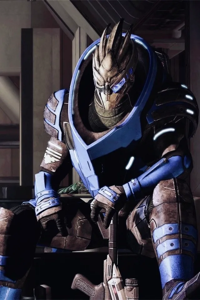 a screenshot of Garrus Vakarian, sitting on a crate with one leg propped up and hid rifle resting bewteen his legs